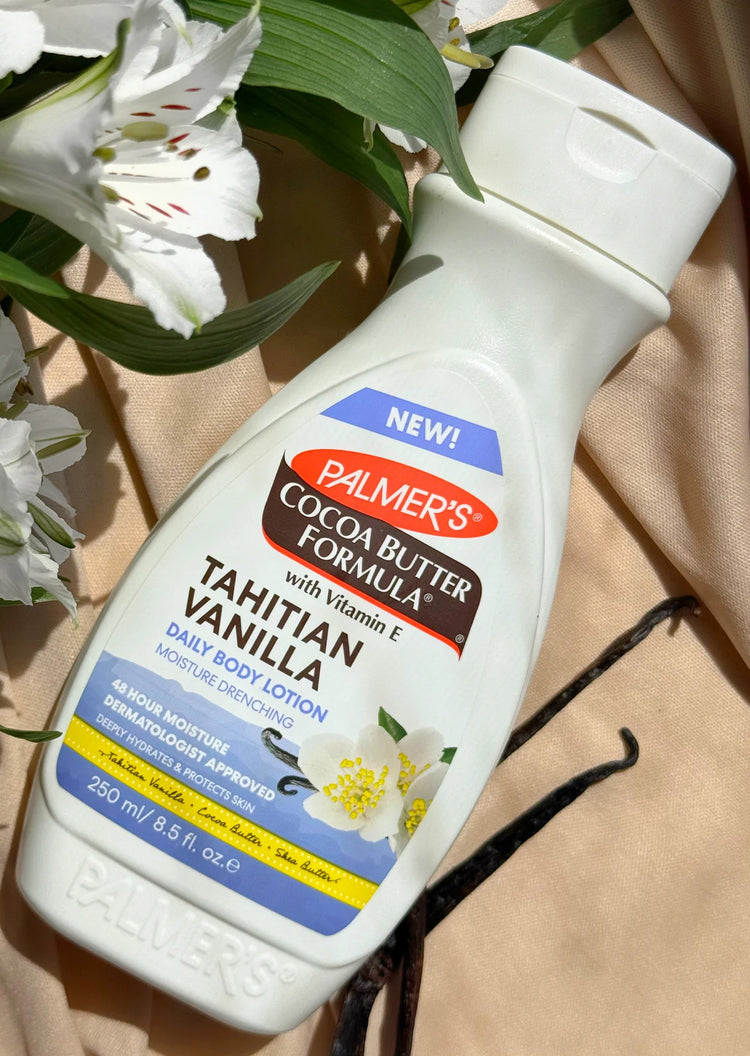  Palmer's Cocoa Butter Formula Tahitian Vanilla body lotion with flowers in the background