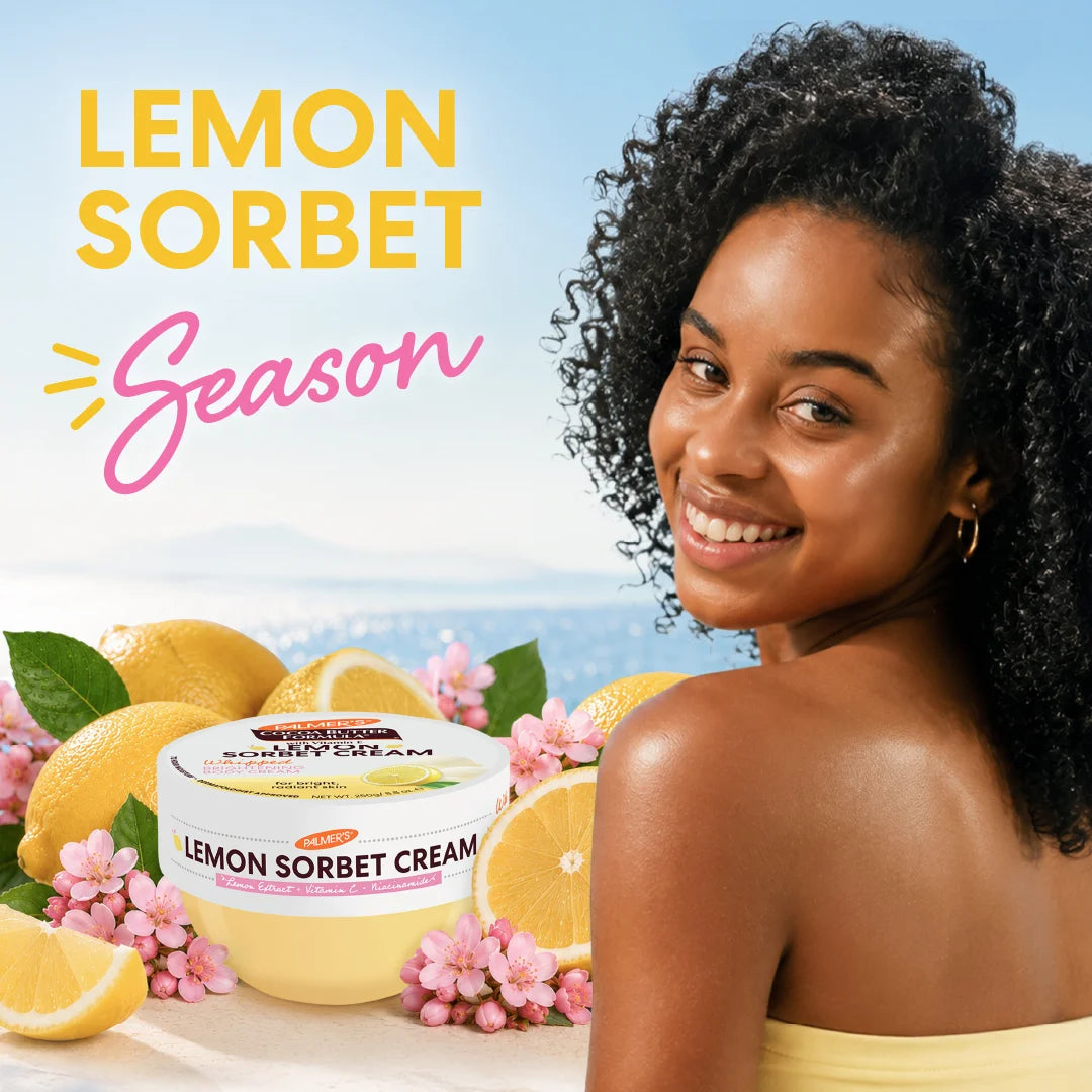 A smiling woman with curly dark hair is shown beside Palmer's Lemon Sorbet Cream, surrounded by lemons, pink flowers, and large text reading 'LEMON SORBET Season' on a bright blue outdoor-style background.
